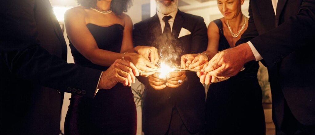 sharply dressed people lighting sparklers