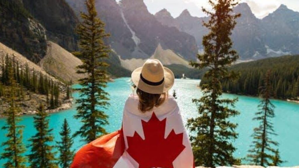 woman in Canadian flag looking at the lake.