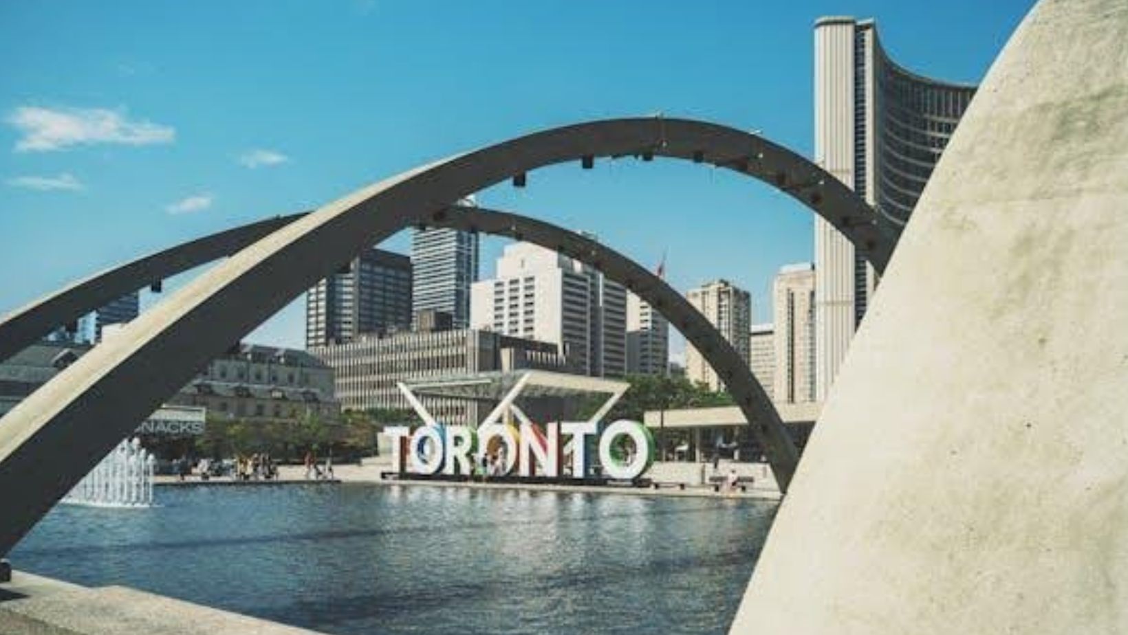 Toronto landmark near pool and many buildings.