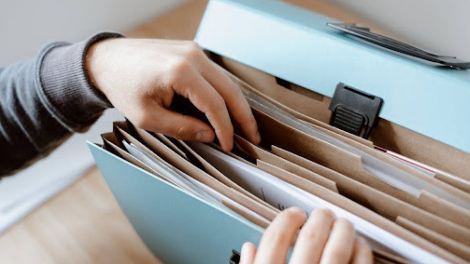 Person looking through a binder with folders and papers